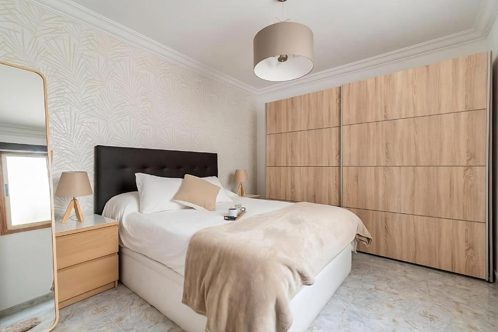 梅莱纳拉Lovely house in Gran Canaria next to the airport的卧室配有一张白色大床和木制橱柜。