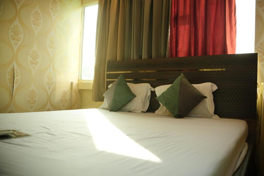 kolkataHOTEL AIRPORT HEAVEN的一间卧室配有带白色床单和枕头的床。