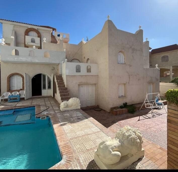 亚历山大Prime location family beach villa - 16 pax的一座大房子,前面设有一个游泳池