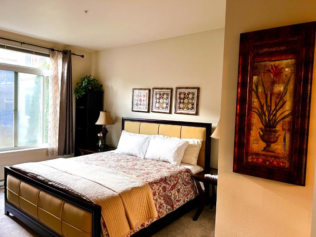 西雅图Cozy home nearby most attractions Seattle center的卧室配有一张床,墙上挂有绘画作品