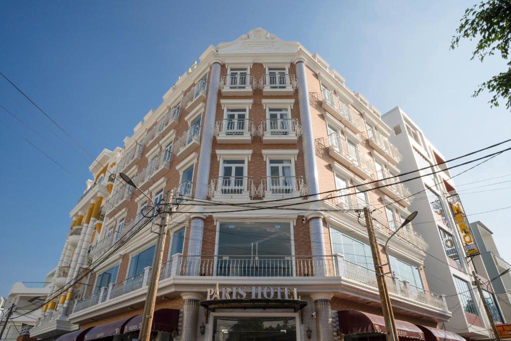 朱笃Paris Hotel Châu Đốc的一座高大的建筑,前面有标志