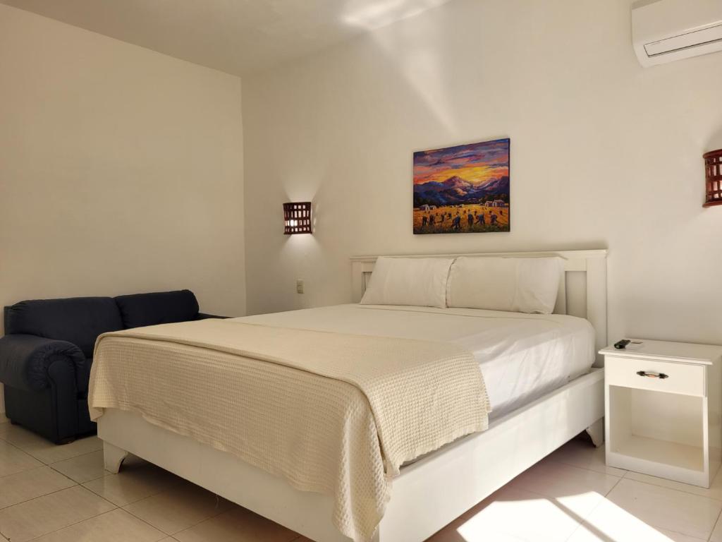圣多明各玻利瓦尔德雷克酒店的卧室配有白色的床和椅子