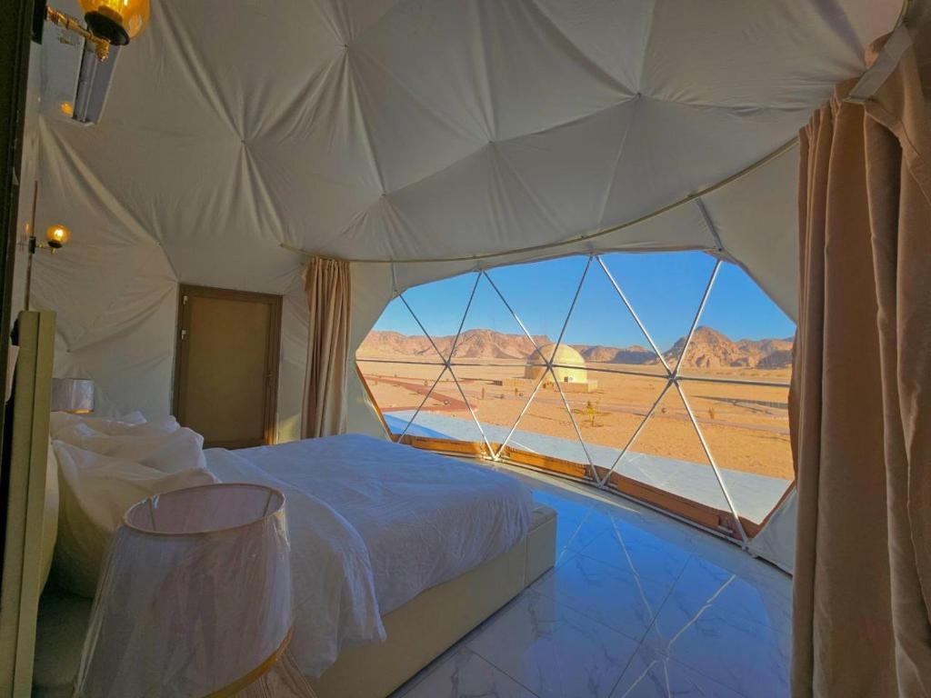 瓦迪拉姆Wadi rum anwar luxury camp的帐篷内的一张床位,享有沙漠美景