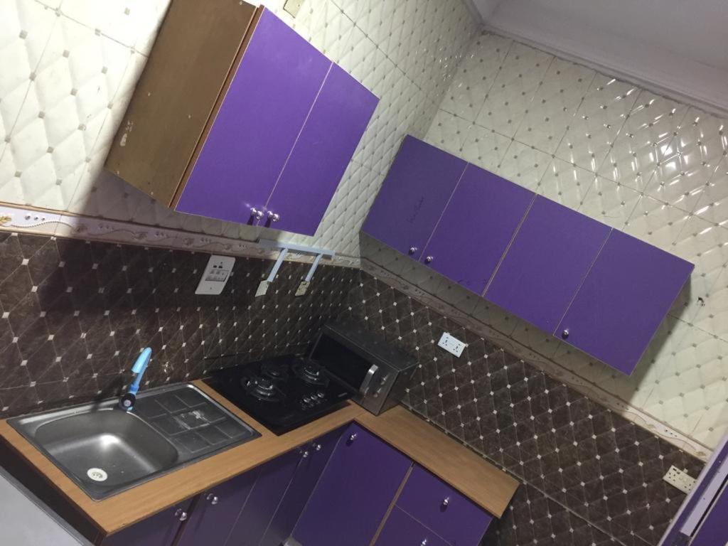 GwarinpaMega Pavilion Apartment And Suits Gwarinpa的一个带紫色橱柜和水槽的小厨房