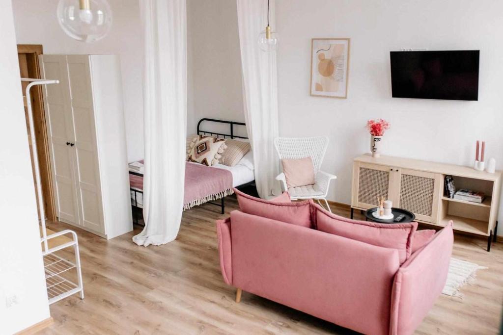 克维曾Apartament Pastelowy Kwidzyn的客厅配有2把粉红色的椅子和1张床