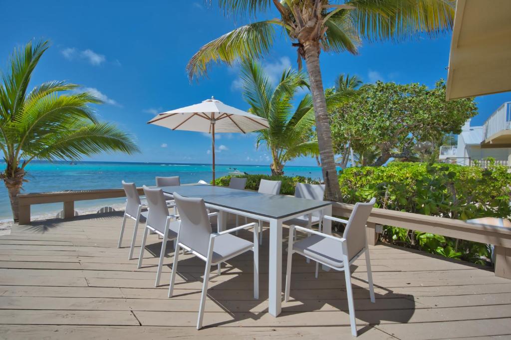 乔治敦Incredible Beach Front Villa!的海滩上的桌椅和遮阳伞