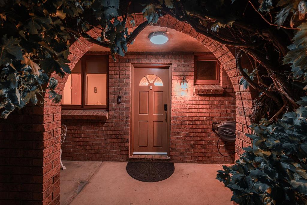 库马Cooma Guest House的砖砌建筑的入口,设有棕色的门