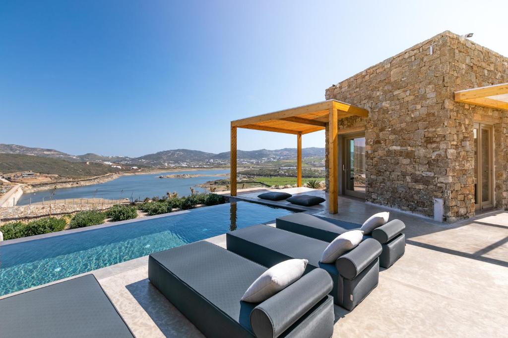 帕诺尔莫斯米科诺斯Panormos Bay Suites Luxury Resort的一座带游泳池和房子的别墅