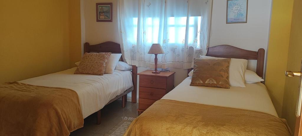 马佐Estrella de Sal的一间卧室配有两张床和床头灯。