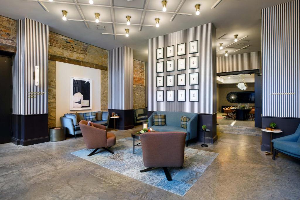 托皮卡Cyrus Hotel, Topeka, a Tribute Portfolio Hotel的大厅,在大楼里摆放着长沙发椅和桌子