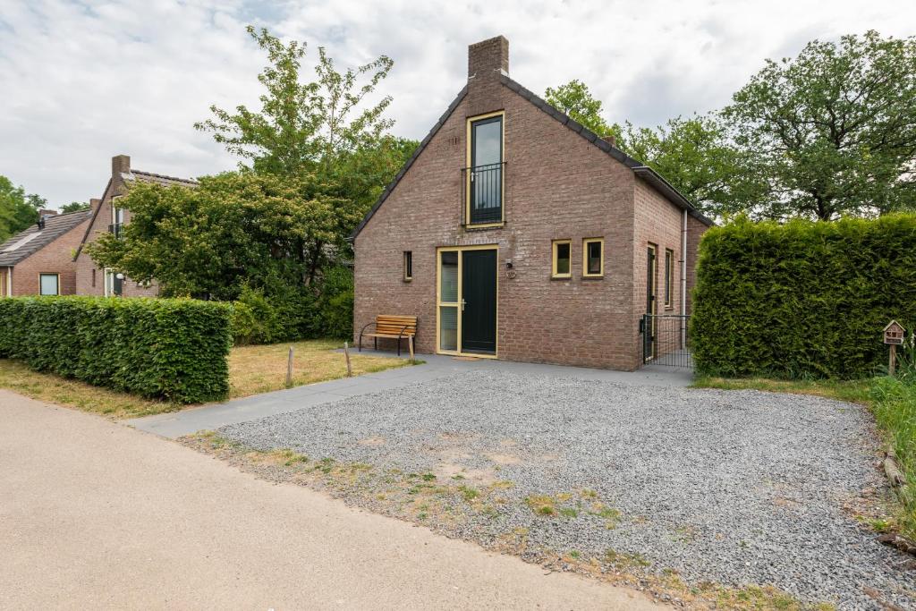 EwijkHet Huys Ewijk mooi luxe en een laadpaal的砖房,前面有长凳