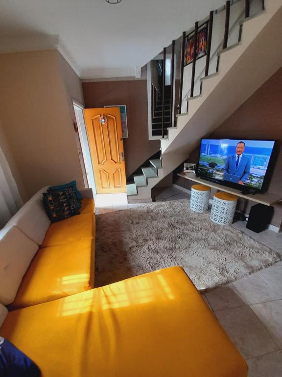 圣保罗Casa do Luis的客厅配有黄色沙发和电视
