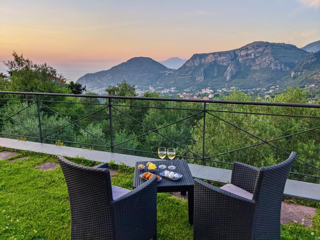 皮雅诺迪索伦托Villa Fanella, between Sorrento & Amalfi的阳台配有桌椅,享有山脉背景