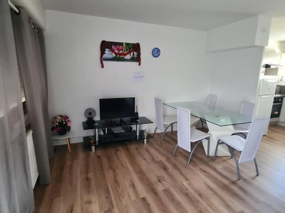 佩萨克APPARTEMENT EN PLEIN CENTRE VILLE PESSAC AVEC 3 CHAMBRES的一间设有玻璃桌和椅子的用餐室