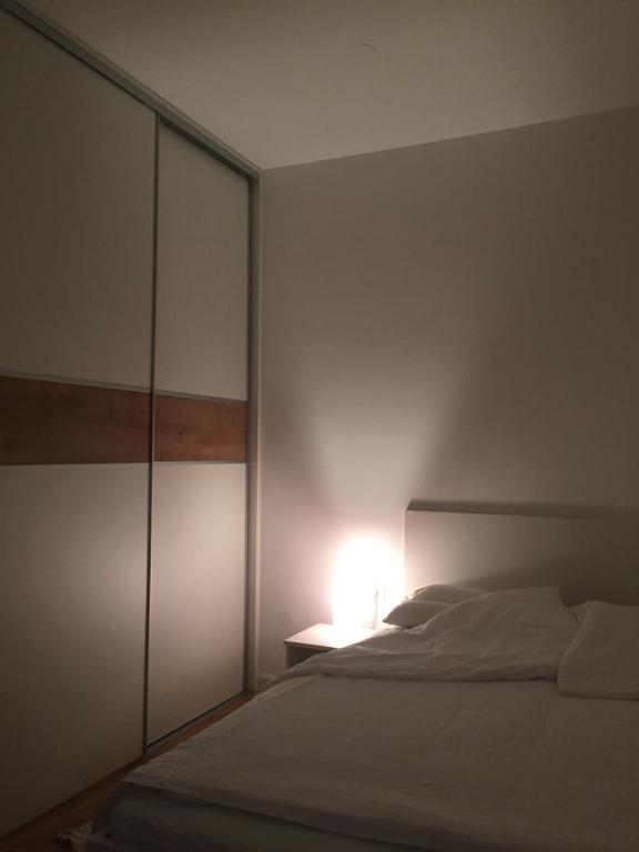 萨格勒布Velesajam的卧室配有白色的床和灯