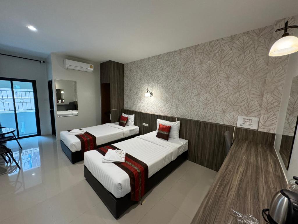 素叻THE HUB SURATTHANl的酒店客房带两张床和一面墙