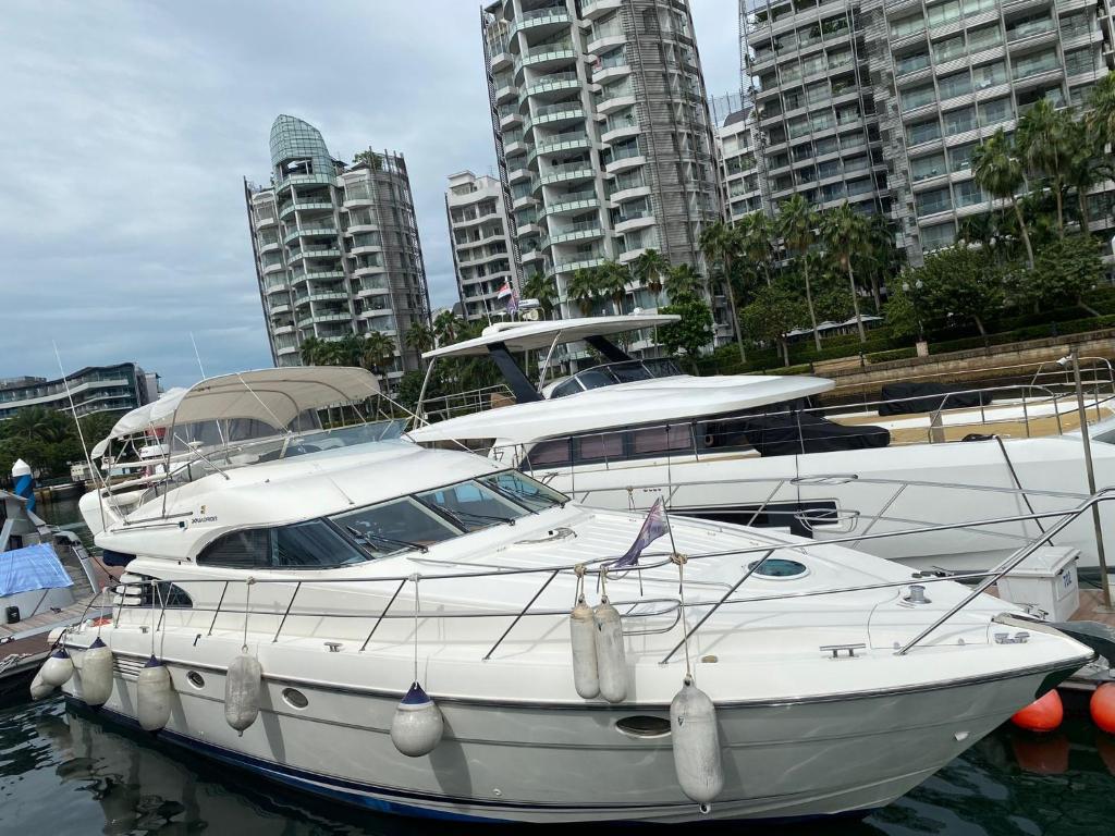 新加坡No.1 Holiday的两艘船停泊在水中,有建筑物