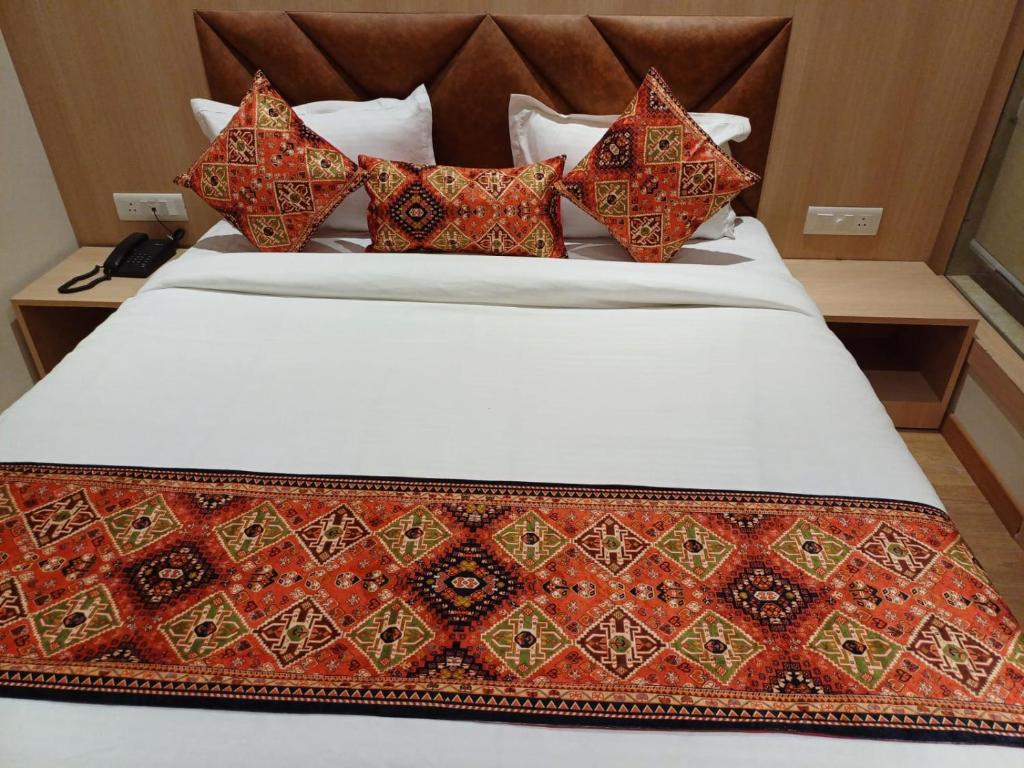 阿姆利则Hotel JR Grand 100 Meter From Golden Temple的一张床上有色彩缤纷的枕头
