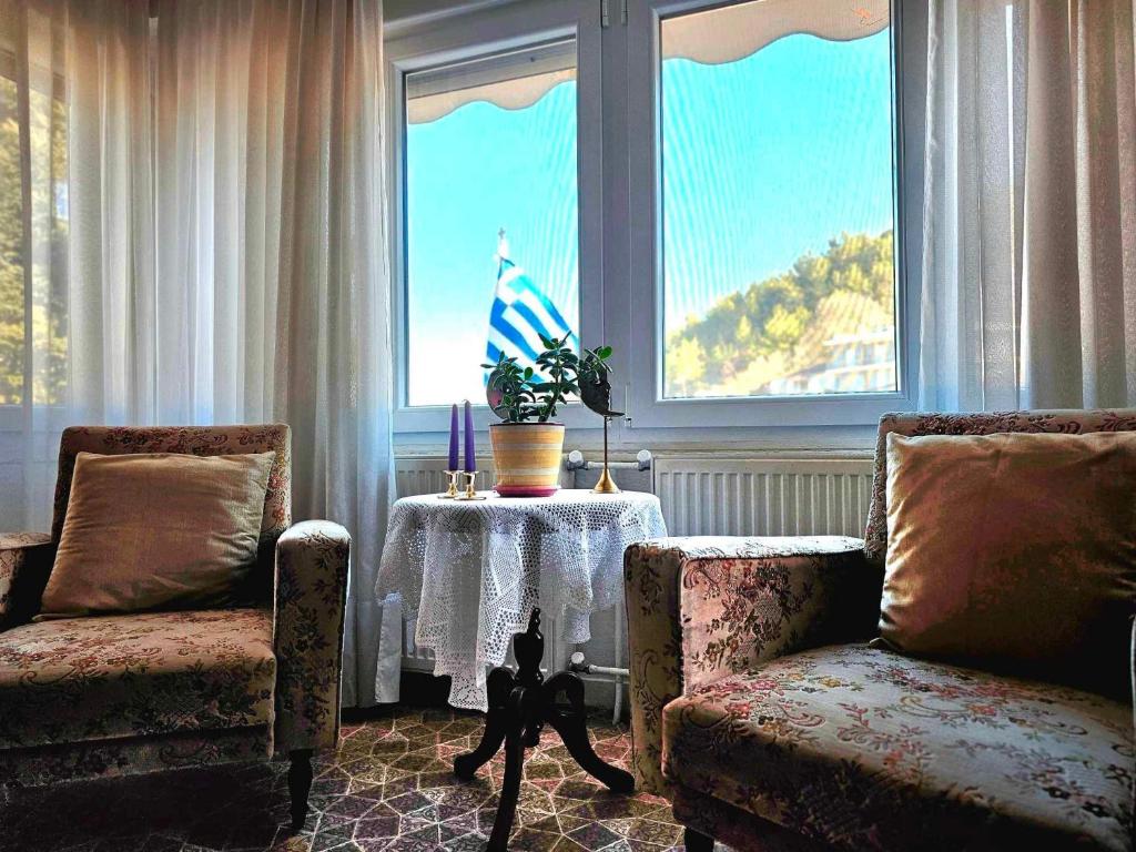 EleftheroúpolisVilla Christina的客厅配有两把椅子、一张桌子和一扇窗户