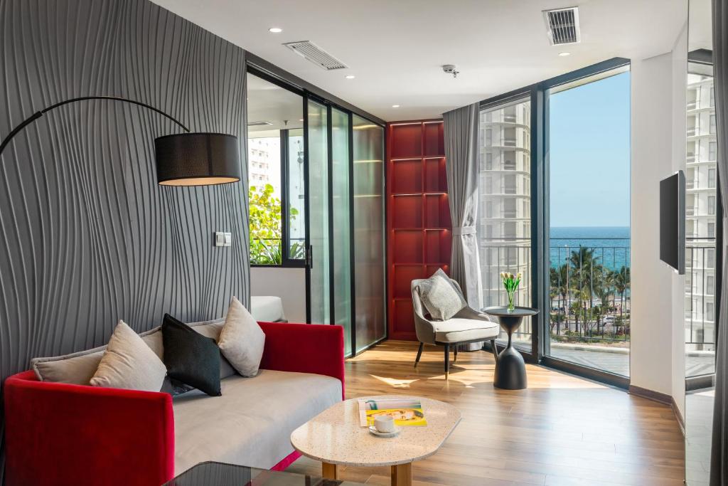 岘港Taiyo Hotel & Apartment的客厅配有红色的沙发和桌子