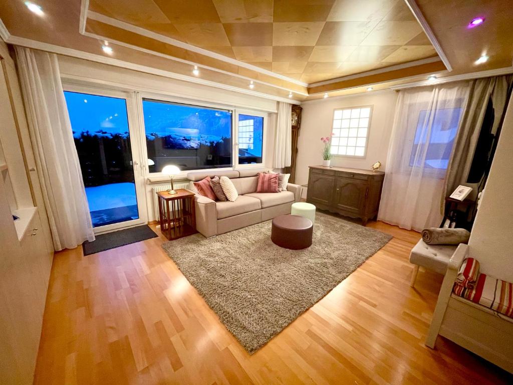 洛伊克巴德Sunny-Nest, Garden Apartment的带沙发和大窗户的客厅