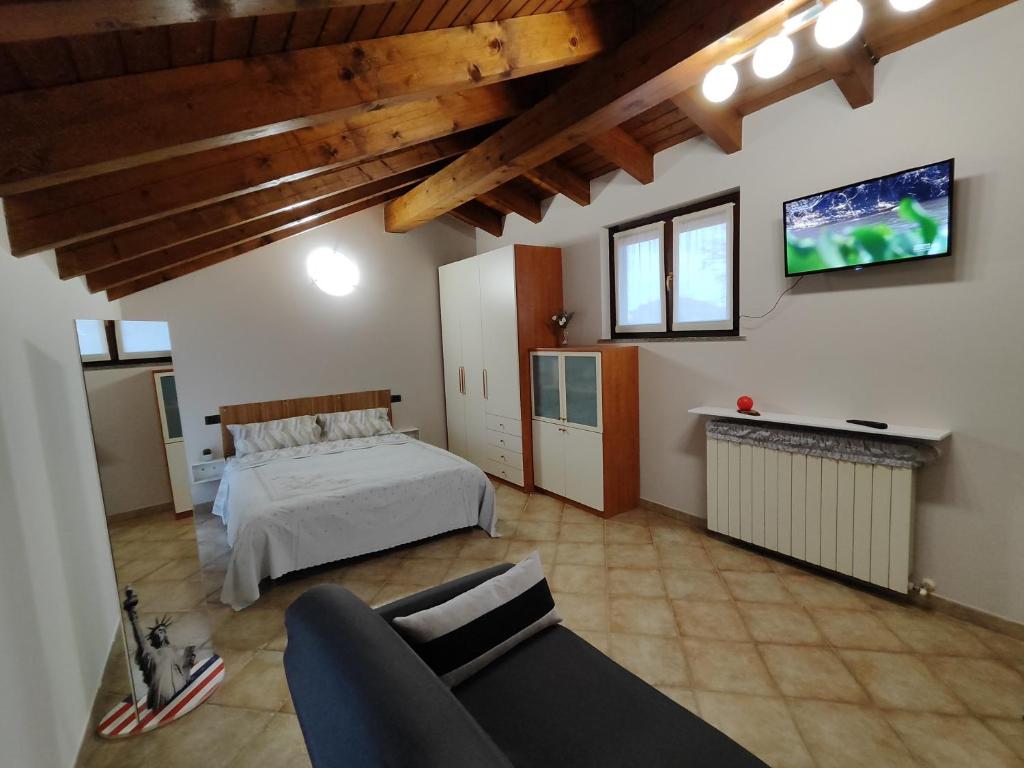 博尔戈马内罗Casa Ninetta的卧室配有一张床,墙上配有电视。