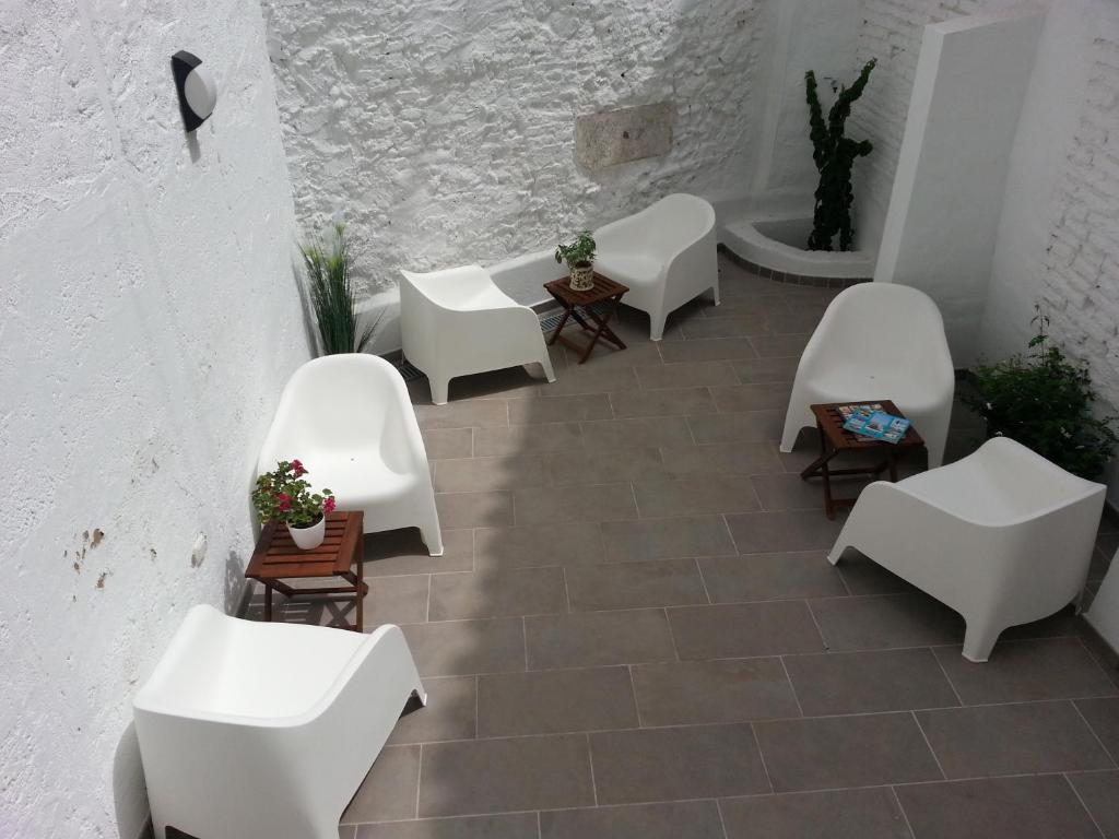 马拉加La Siesta de Picasso的庭院配有白色的椅子和桌子。