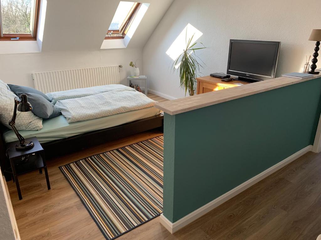 门兴格拉德巴赫Kleines Apartment in Mönchengladbach-Neuwerk的一间卧室配有一张床和一台平面电视