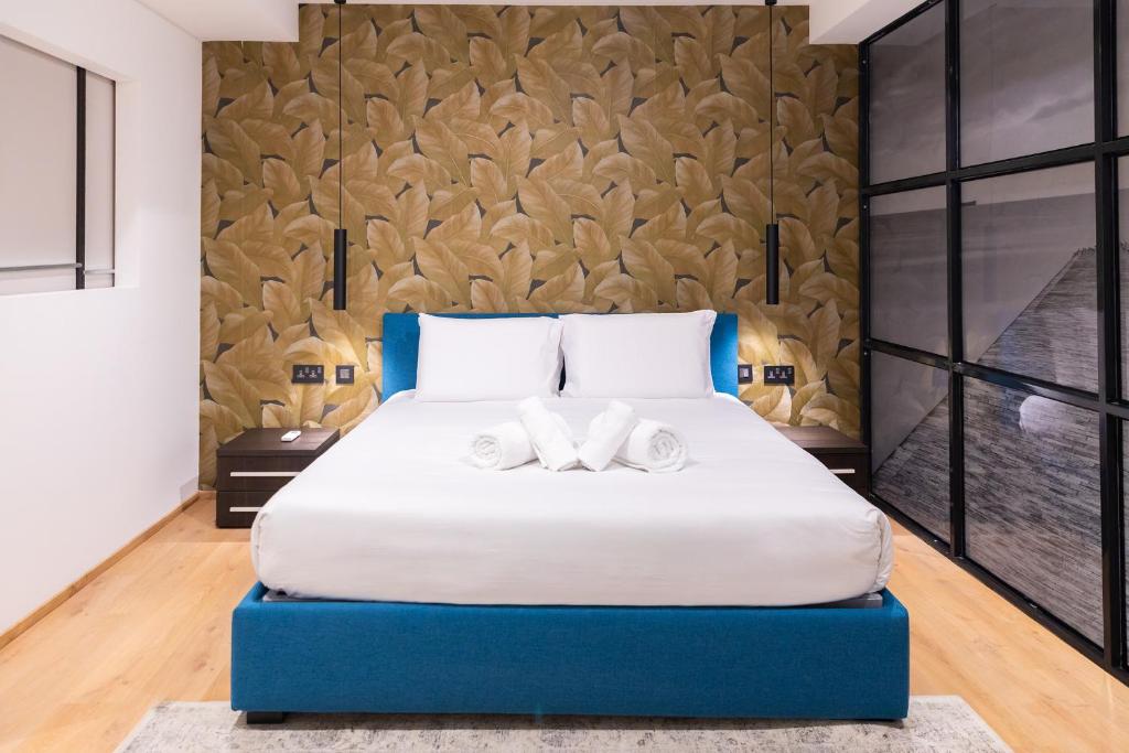弗洛里亚纳Florette Suite 1BR in Floriana的一间卧室配有一张大床和两条毛巾