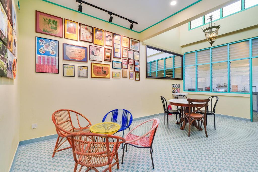 怡保梦想与漫游民宿的用餐室配有桌椅,墙上挂有图片