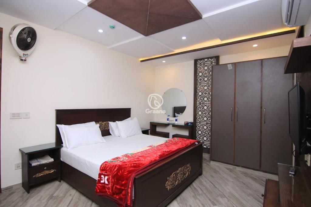 拉合尔Multazam Heights, DHA Phase 8的一间卧室配有一张带红色毯子的大床