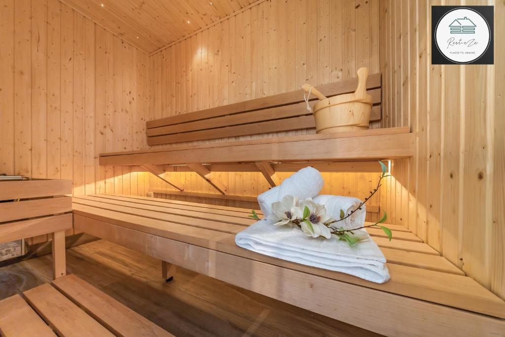 沃金Romantic getaway UK with Private Sauna, King Bed, WiFi 517mbps & EV Charger的毛巾上放着一束鲜花的桑拿