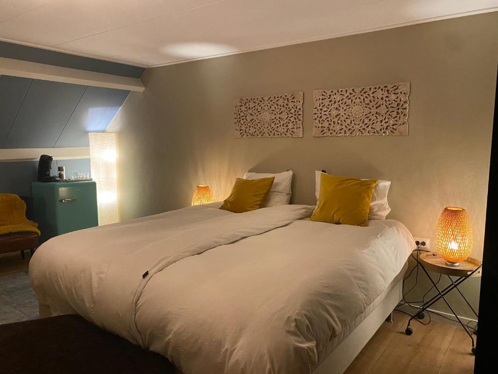 阿纳姆Bed and breakfast Carma Arnhem的卧室配有一张带黄色枕头的大型白色床。
