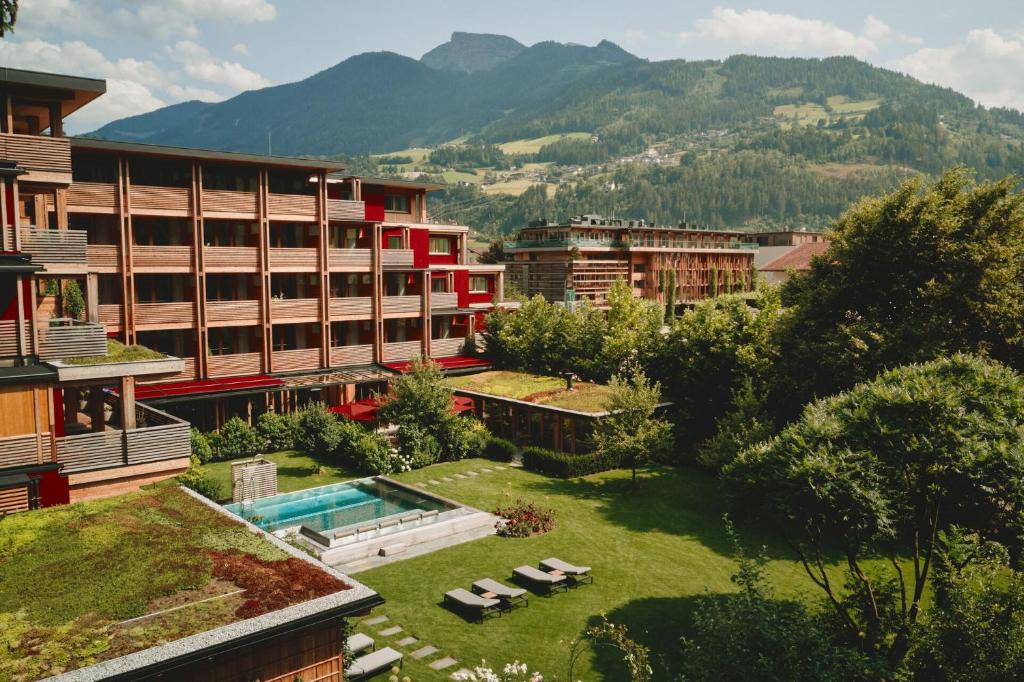 齐勒河谷采尔MalisGarten Green Spa Hotel的一座带游泳池和部分建筑的度假村
