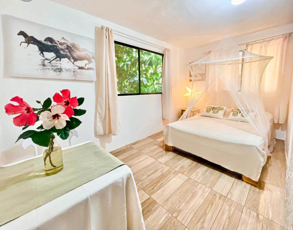拉斯加勒拉斯拉哈仙达旅舍的一间卧室,配有一张床,桌子上放着花瓶