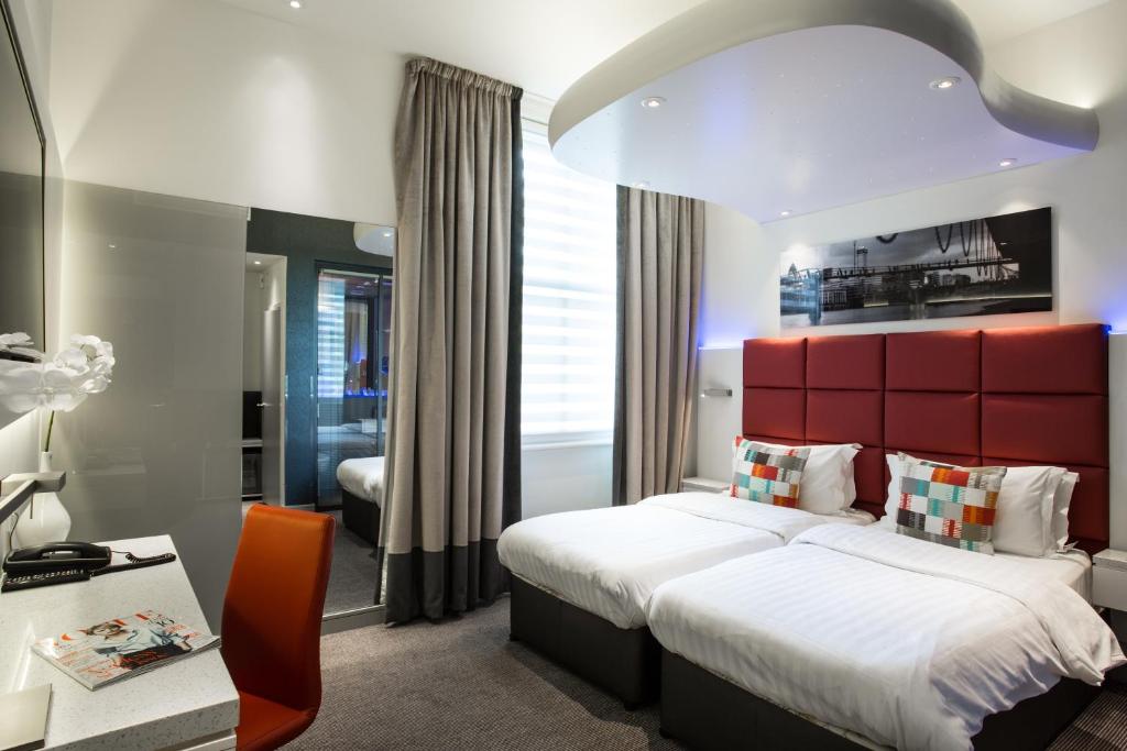 伦敦亨利大厦酒店的一间卧室设有一张大床和红色床头板