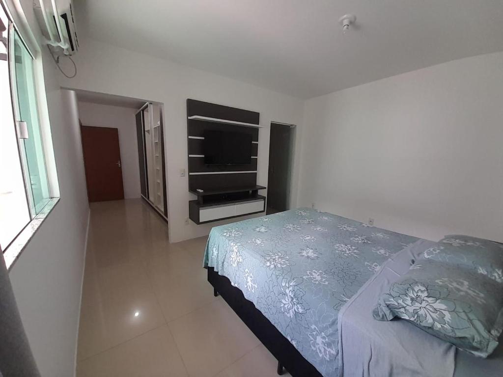 纳韦甘蒂斯Casa a 200 mts da praia - prox Aeroporto NVG - CASA DA MEIA PRAIA的一间卧室配有一张床和一台平面电视