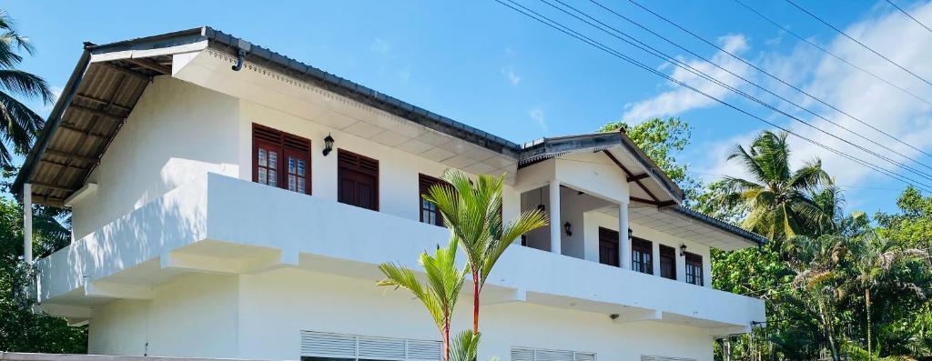 阿杭格默Riparian Ahangama的一座棕榈树掩映的白色房子