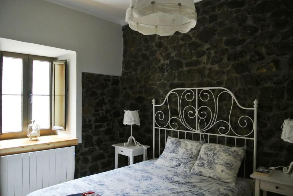 波拉·德莱纳La casa'l cantirín的一间卧室设有一张床和石墙