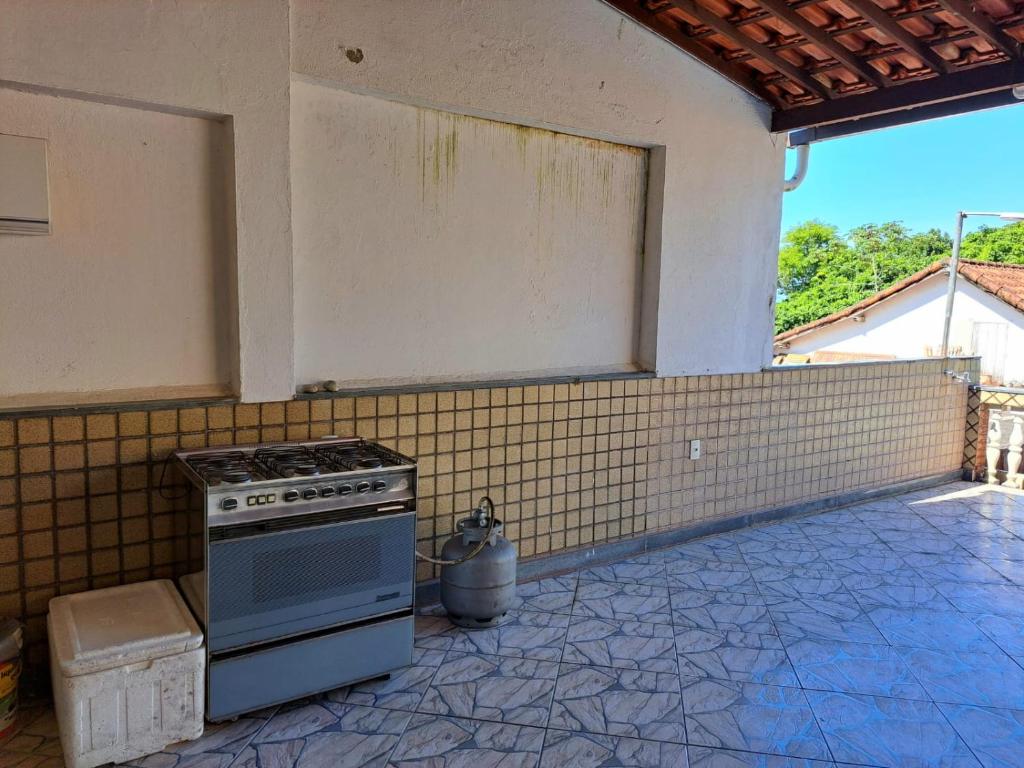穆里基镇Casa Costa Verde-Muriqui的厨房配有炉灶和瓷砖墙。