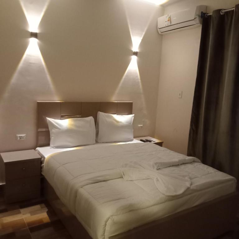 开罗Cairo de casa hostel的一张带白色床单和枕头的床