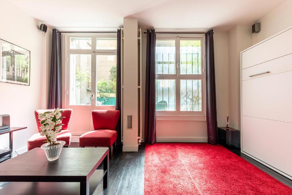 巴黎Studio sur les Quais de Seine的客厅配有红色椅子和红色地毯