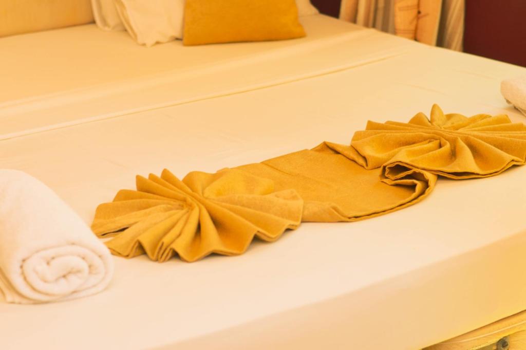 蒙巴萨Roma Stays - Magnificent 4BR at Sunset Paradise Shanzu with a Swimming Pool的两张白色的床,配有黄色的床单和毛巾