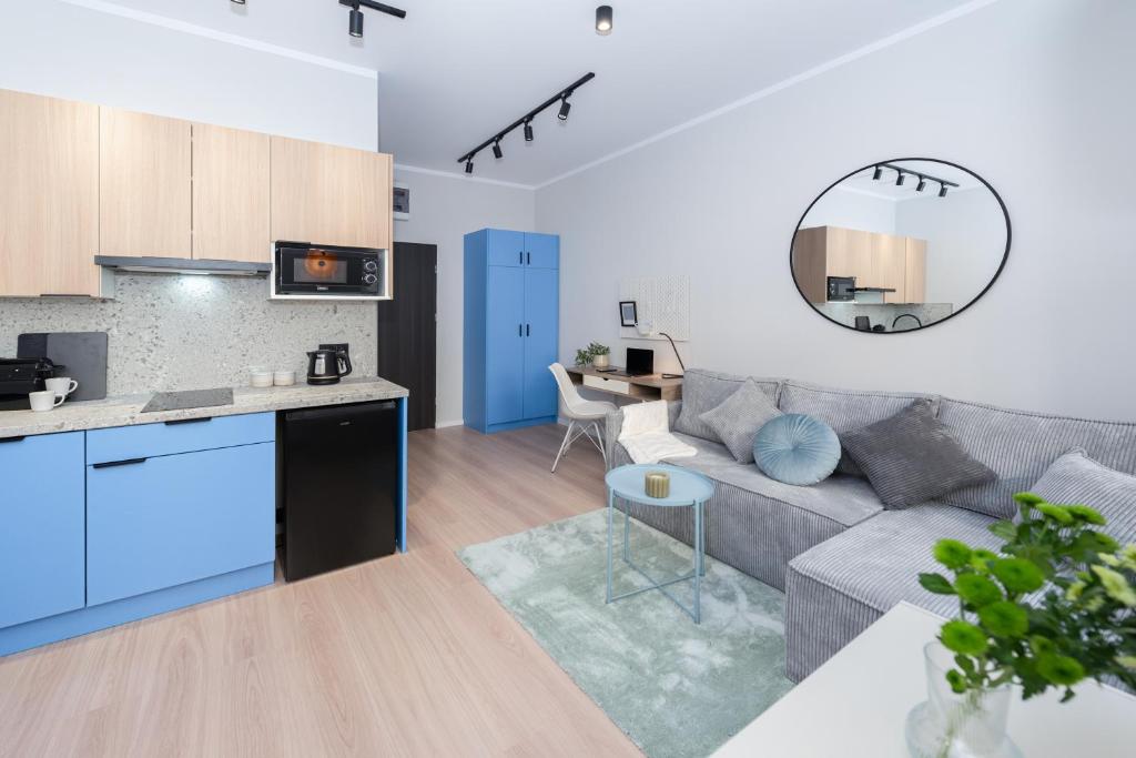 卡托维兹Apartament Plebiscytowa 32的客厅以及带沙发和桌子的厨房。