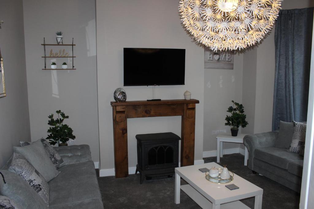 斯卡伯勒Ashville Grange的客厅设有壁炉和平面电视。