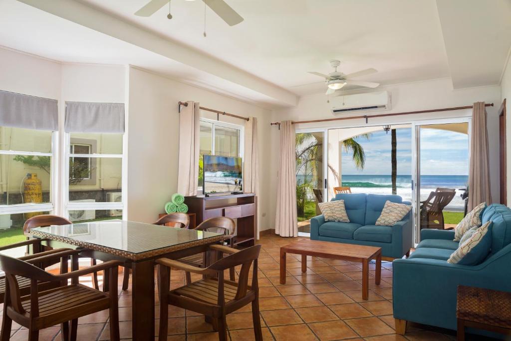 IguanaVillas Iguana A-14 Beachfront Condo的客厅配有蓝色的沙发、桌子和椅子