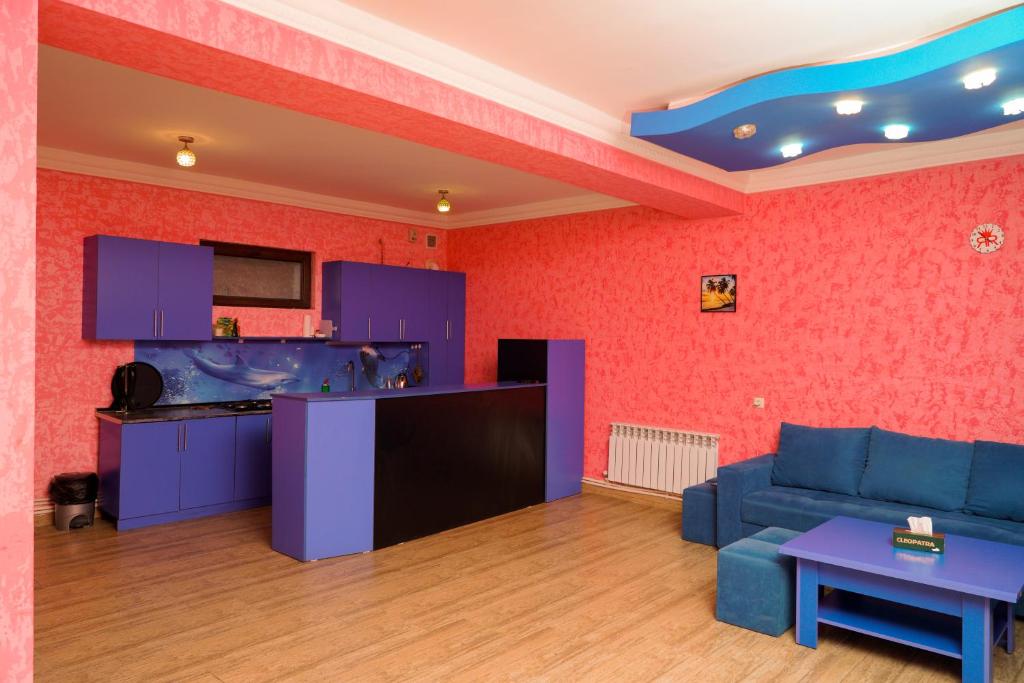 迪利然Royal Rest Townhouse的一间带蓝色沙发的客厅和一间厨房
