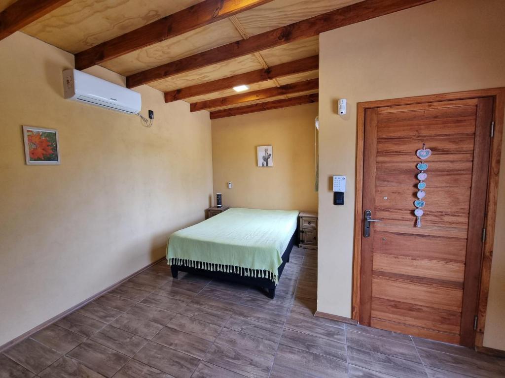 德尔迪阿布罗角Hermoso Monoambiente En Punta Del Diablo - Rocha的一间卧室配有一张床和一扇木门