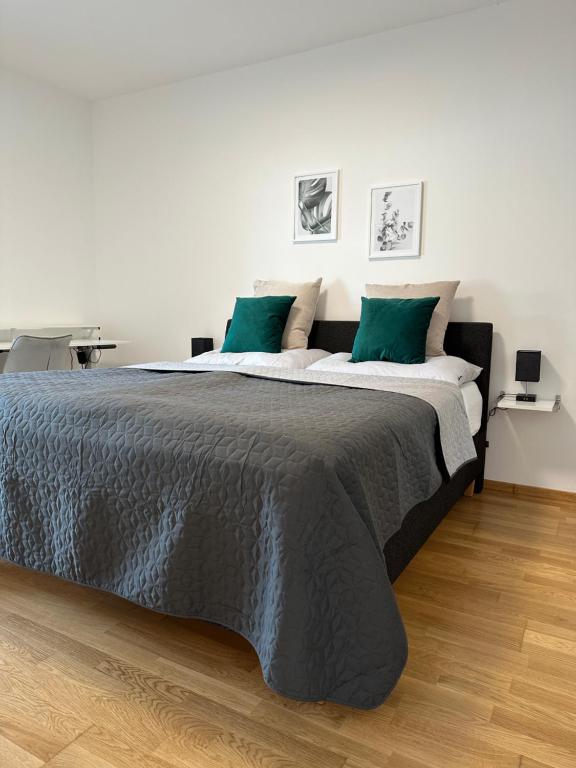 拉斯尼茨霍Harmony Living - 10 min to Graz的一间卧室配有一张带绿色枕头的大床
