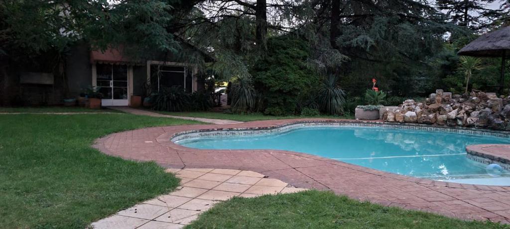 约翰内斯堡Silken Trap Guest House NO LOADSHEDDING的一座房子的院子内的游泳池